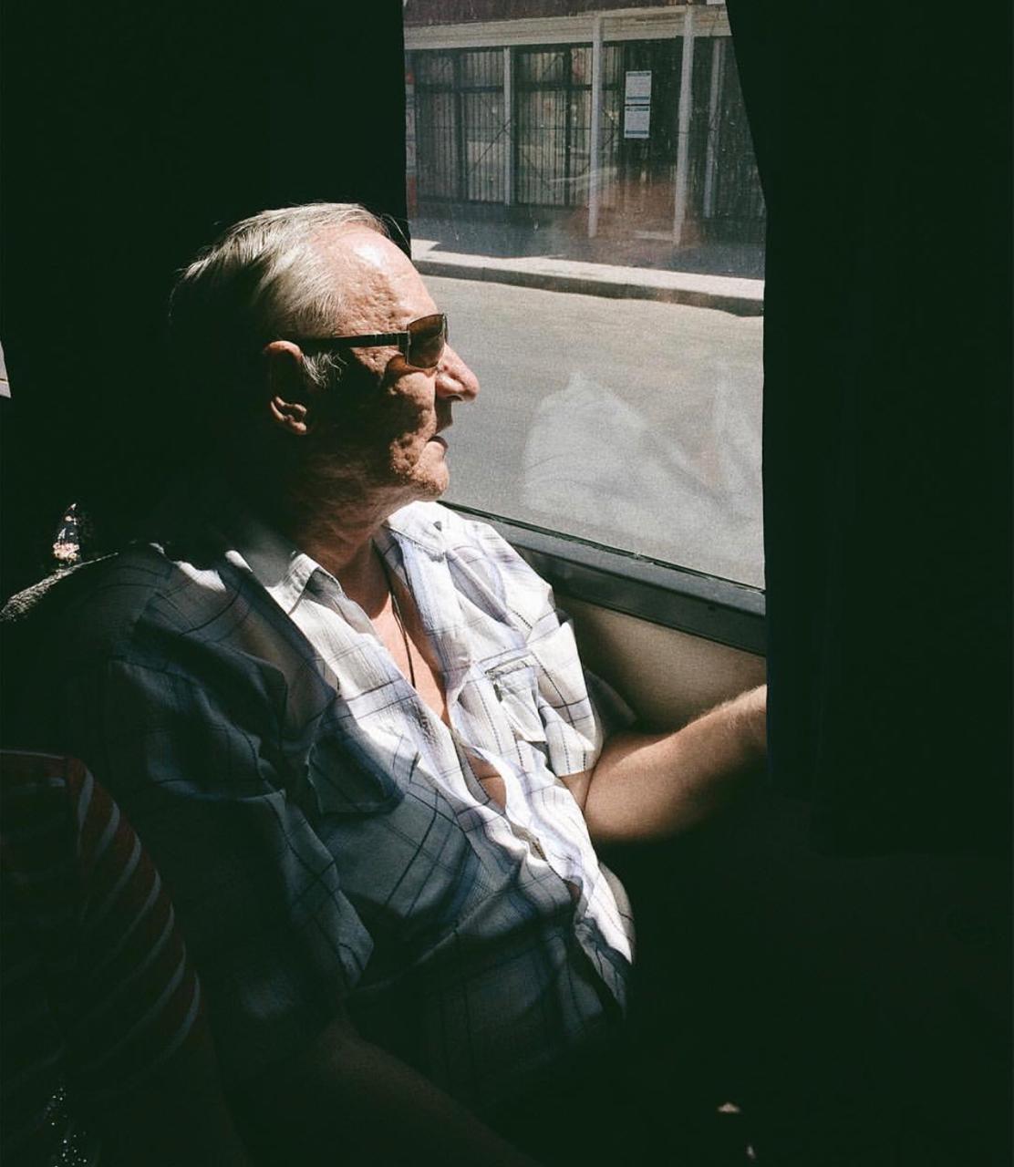 пожилой человек смотрит в окно